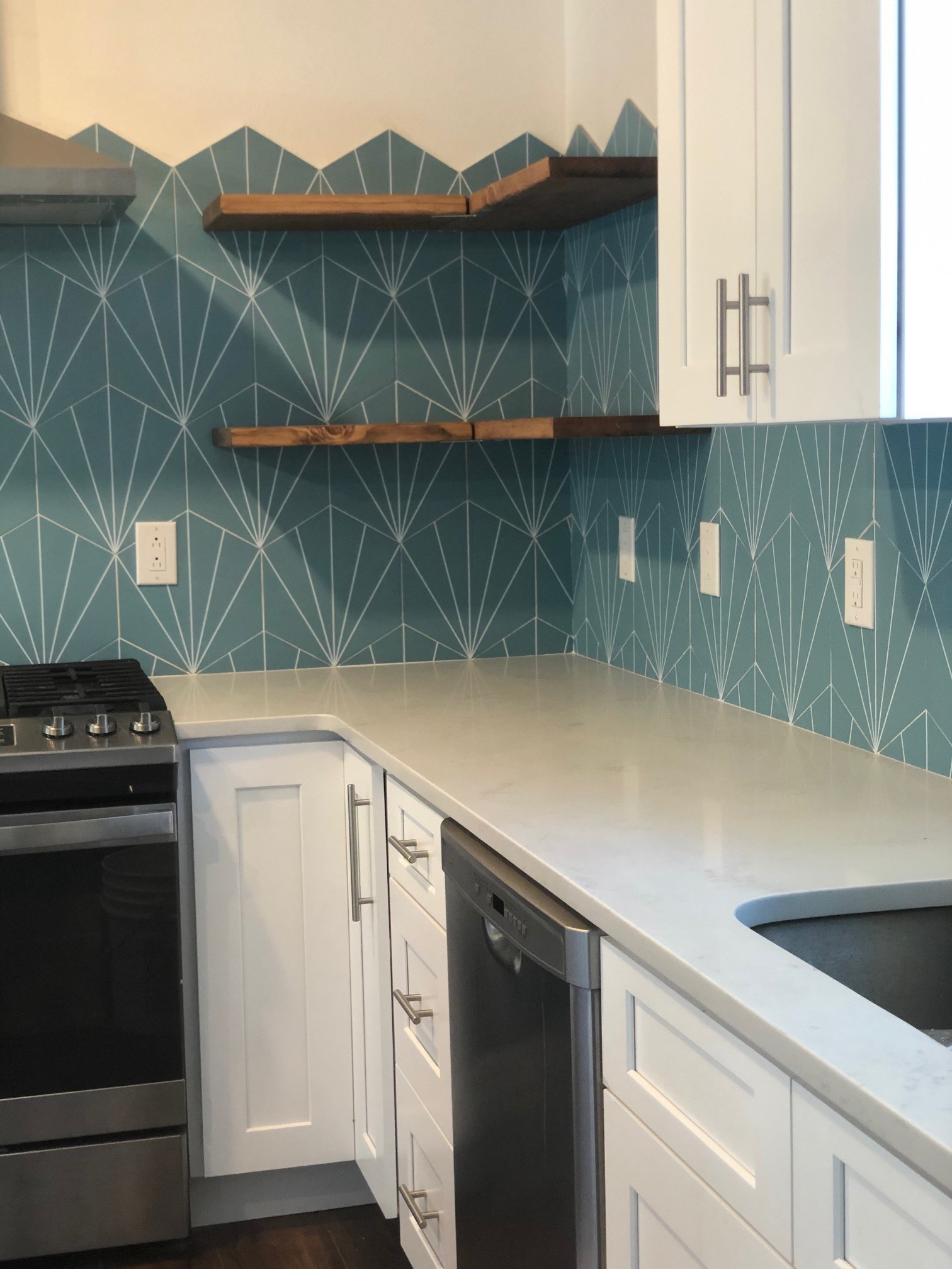 Teal starburst backsplash detail with wood shelves