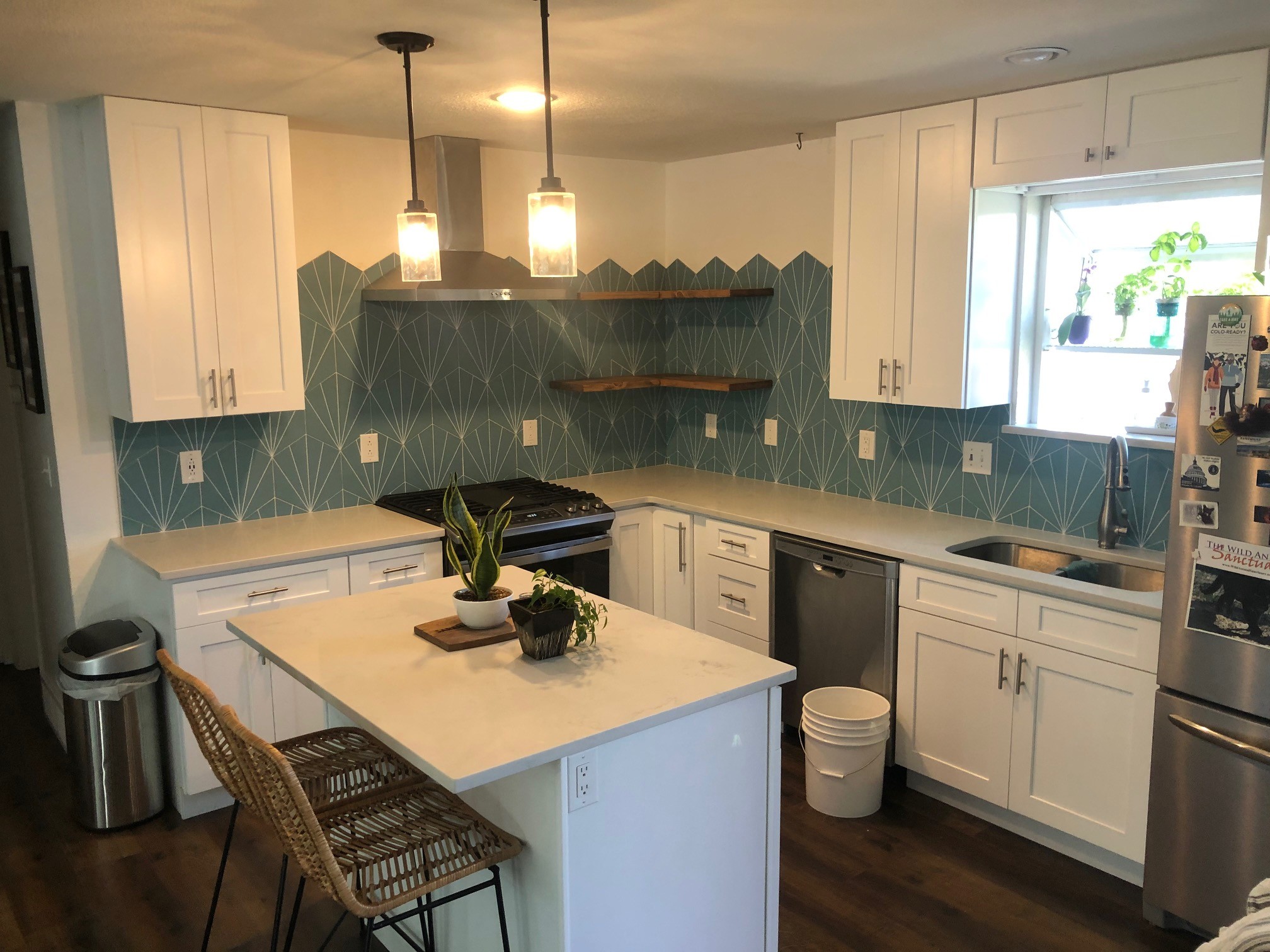 Finished kitchen with white shaker cabinets and teal geometric backsplash